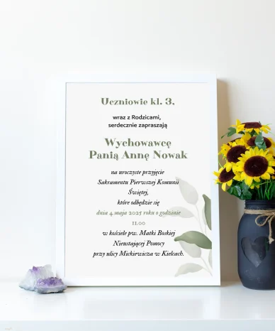 Zaproszenie na Pierwszą Komunię Świętą dla Wychowawcy w białej ramie z zielonymi liśćmi na tle jasnej ściany